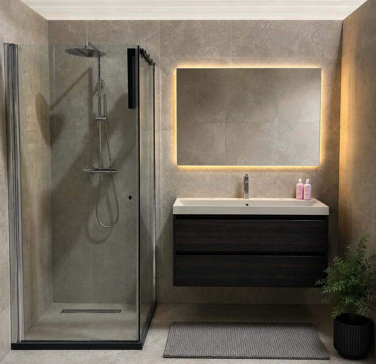 Complete badkamer met betonlook tegels, matzwart kraanwerk en een douchecabine met regendouche